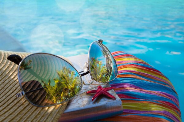 Lunettes de soleil et une étoile au bord de la piscine