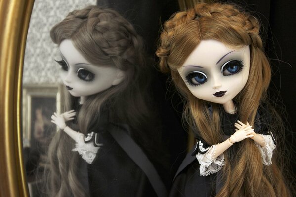 Gotycka lalka przy lustrze w czarnej sukience