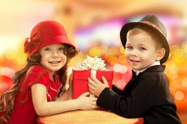 Children in hats are holding a gift