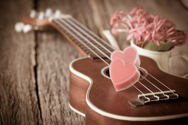 Two hearts are lying on an old guitar