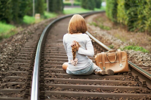 The girl got a haircut on the floor of the square and sat on the rails