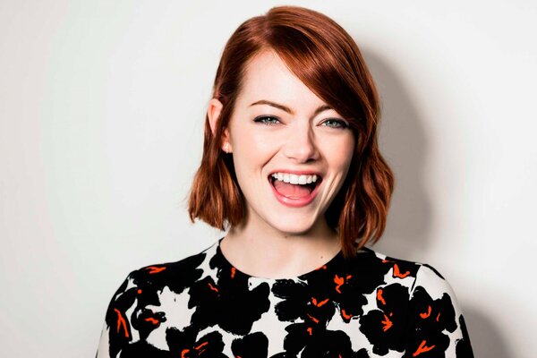 Emma Stone in a colorful outfit laughs
