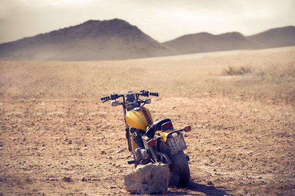 Vecchia moto in un campo su uno sfondo di colline