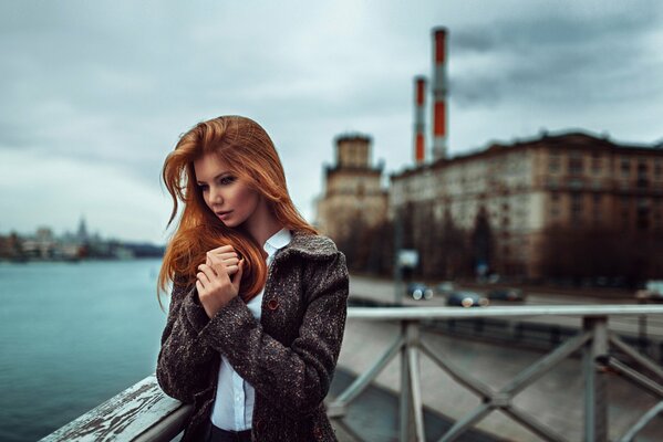 A lonely girl is standing near the river