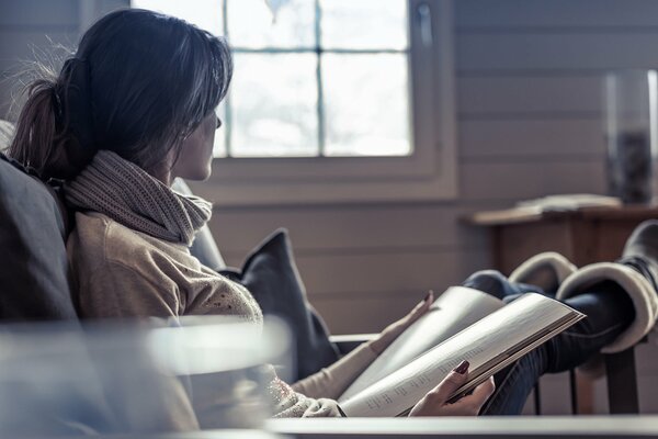 Das Mädchen sitzt auf einem Stuhl und liest eine Zeitschrift