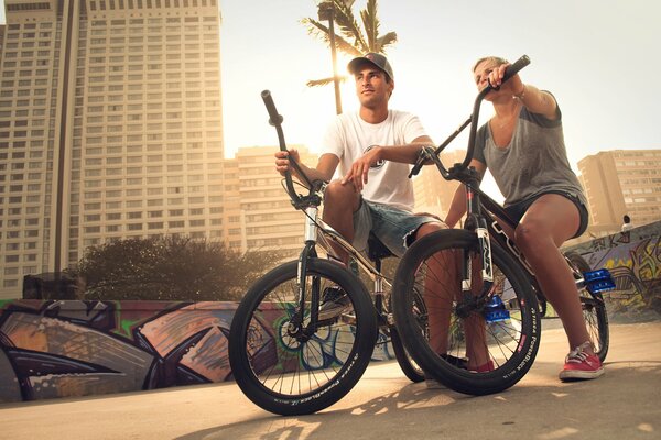 Chica y hombre en bmx en la ciudad