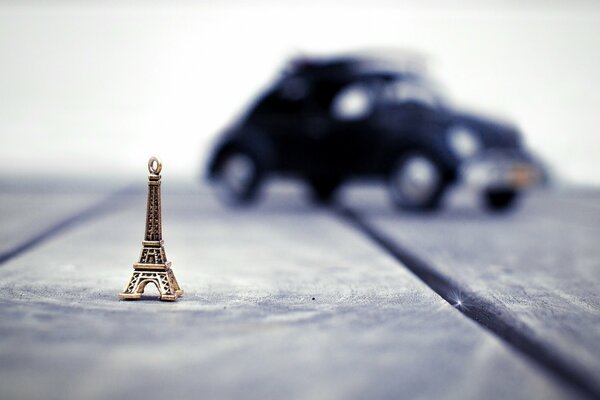 La pequeña torre Eiffel contra un coche borroso
