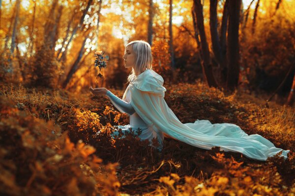 Mädchen im Wald mit einer Rose in den Händen