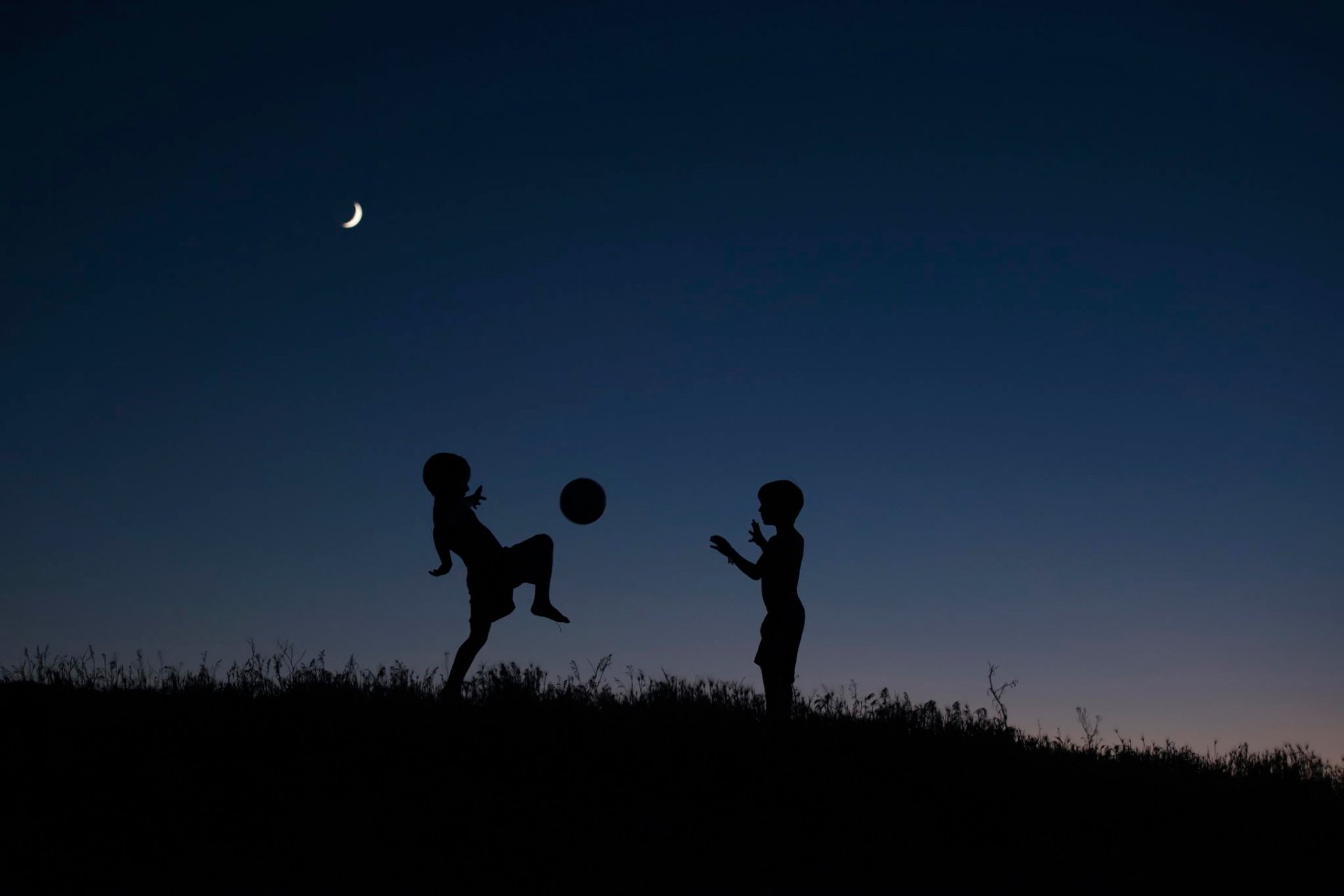 niños siluetas noche pelota juego