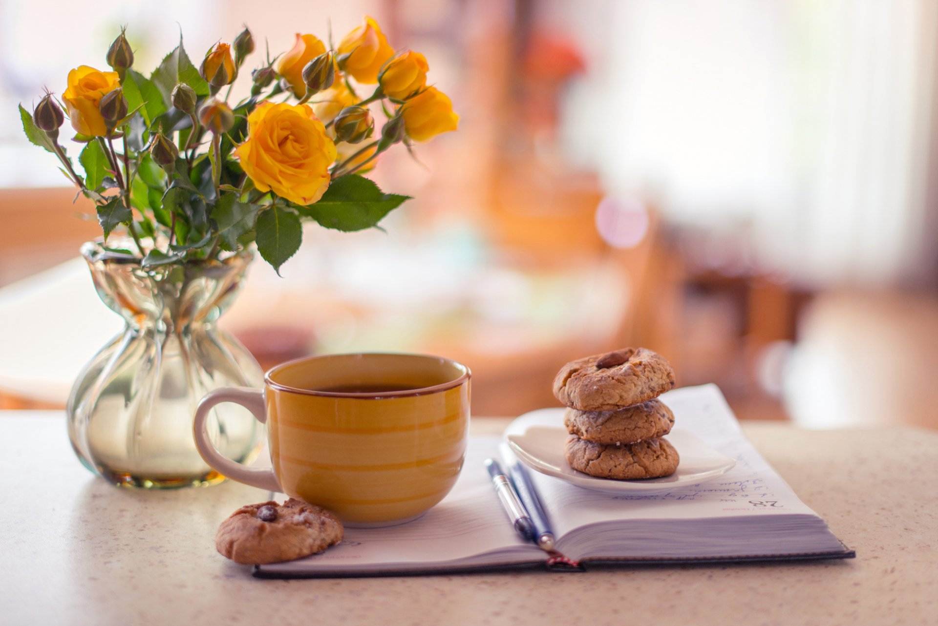 florero rosas amarillo cuaderno plumas taza té café galletas hornear