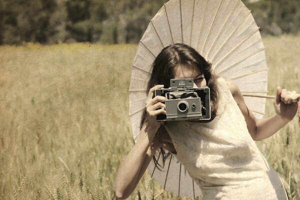 A girl in a white dress with an umbrella and a camera