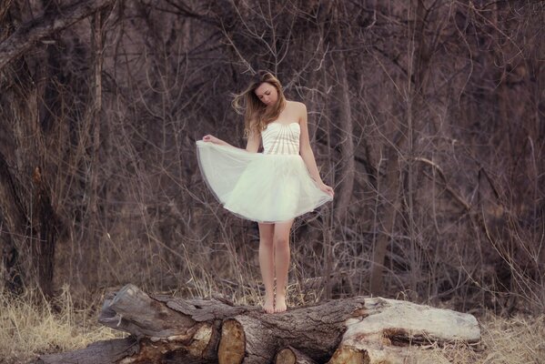 A girl in a white dress in the forest