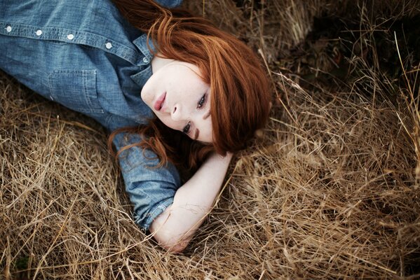 Red-haired girl on a haystack