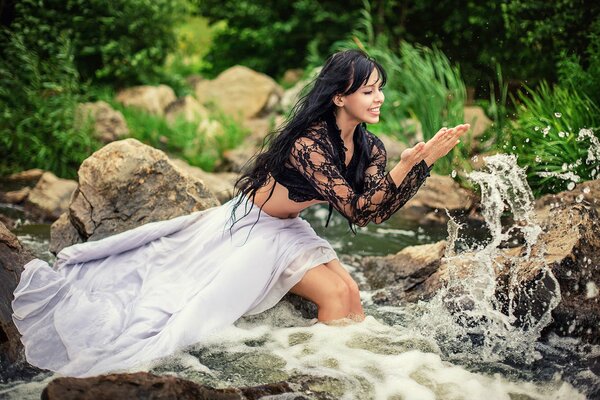 Belle fille dans la rivière, se réjouit de projections et de l eau