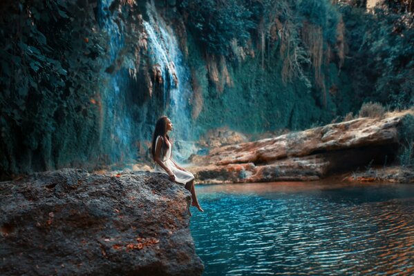 Bella ragazza sullo sfondo di una cascata