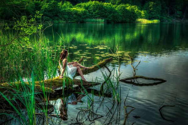 Bosque, lago. Chica se baña los pies