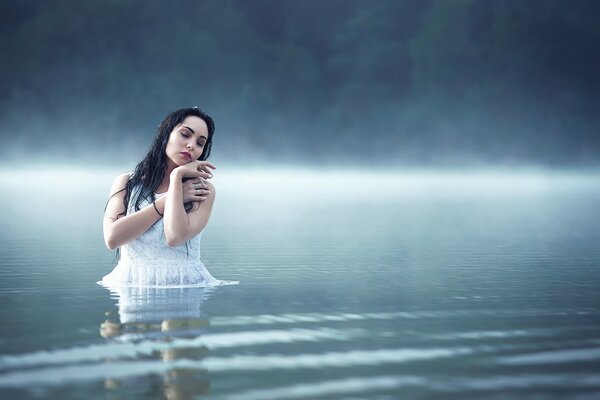 Foto de una chica en un lago de niebla