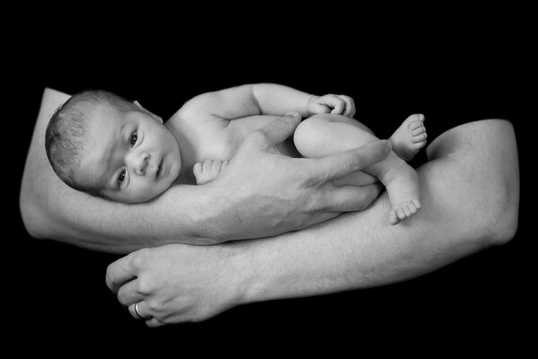 Bébé dans les mains fortes de papa