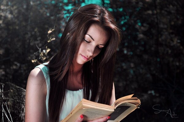 Mädchen mit dunklen Haaren liest ein Buch