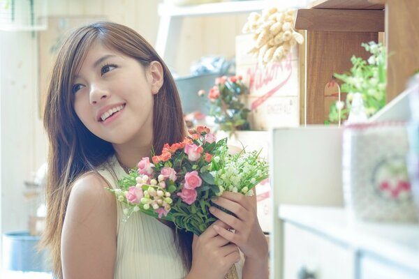 Fille asiatique avec un bouquet de fleurs