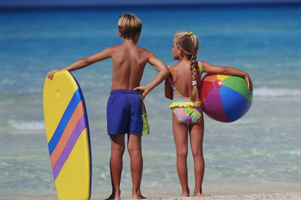 A girl and a boy look into the sea