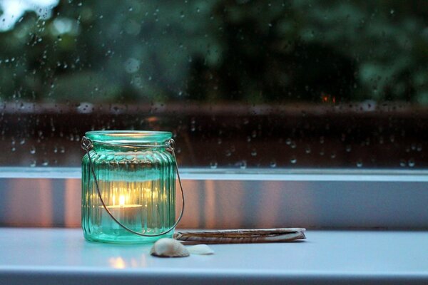 A lamp on the windowsill a candle in a jar