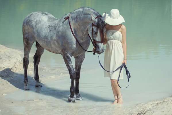 La ragazza con il cappello cammina il cavallo