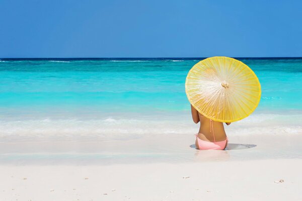 Sul mare con ombrello ragazza sulla spiaggia