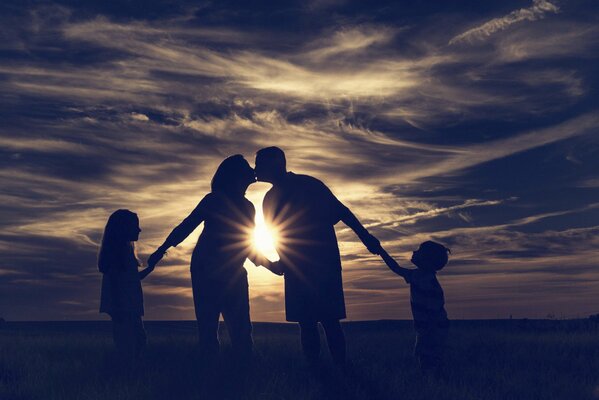 Familie am Meer trifft den Sonnenuntergang