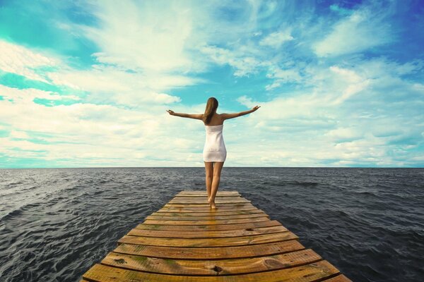 Chica en el vestido, entre el cielo y el océano