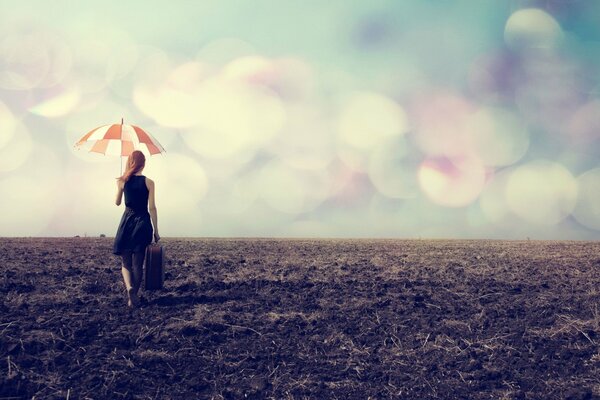 Ein Mädchen mit einem Koffer geht unter einem Regenschirm über ein staubiges Feld