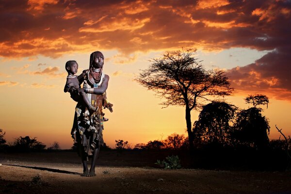 A woman looks at the sunset of the passing day