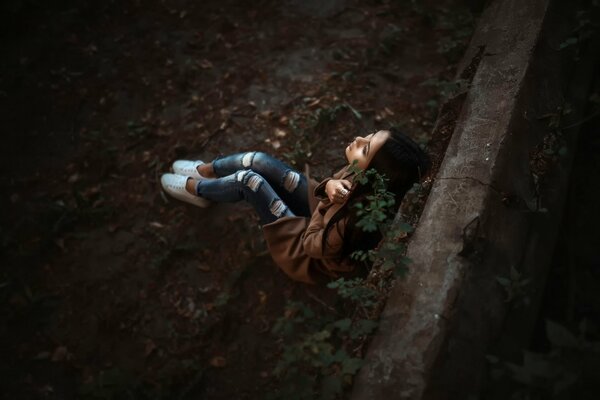 Chica en jeans sentado en el Suelo