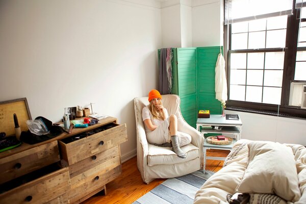 Elizabeth Olsen dans la pièce est assise dans un chapeau orange sur une chaise