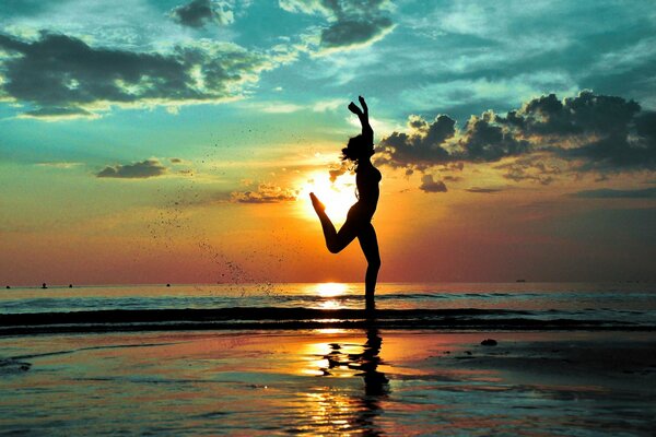 Am Strand läuft ein fröhliches Mädchen mit einer Silhouette