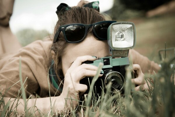 A girl with an old camera in nature in a field