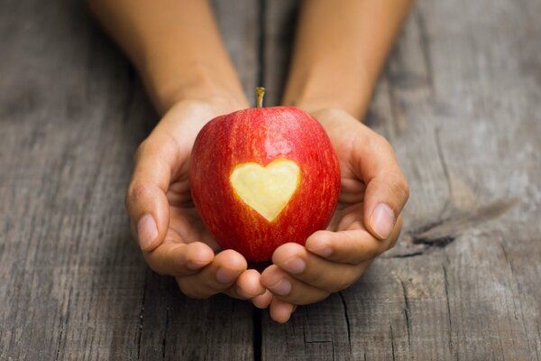 Jabłko z wyciętym sercem w dłoniach
