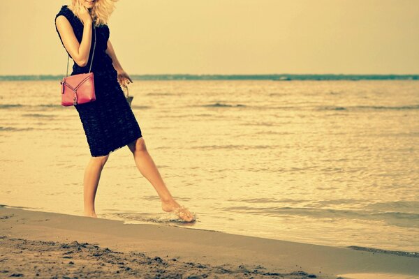 Promenade blonde fille sur le sable de la mer