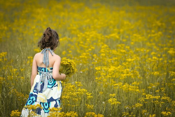 Fille dans une robe légère avec un bouquet de fleurs parmi les fleurs