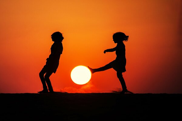 Silhouetten von Kindern bei Sonnenuntergang