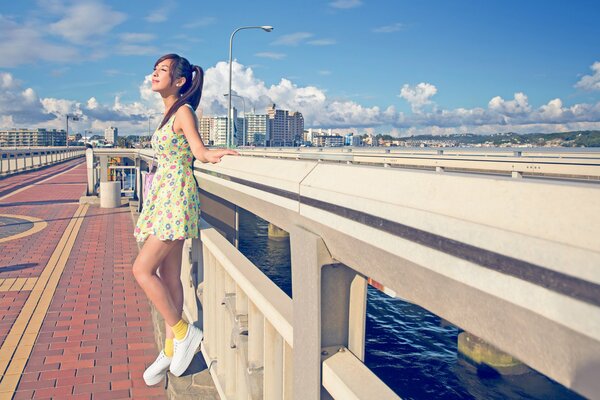 A girl in a dress on the embankment