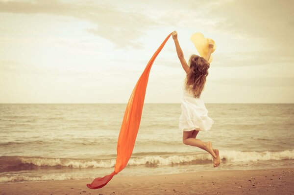 Fille de saut joyeux sur la plage