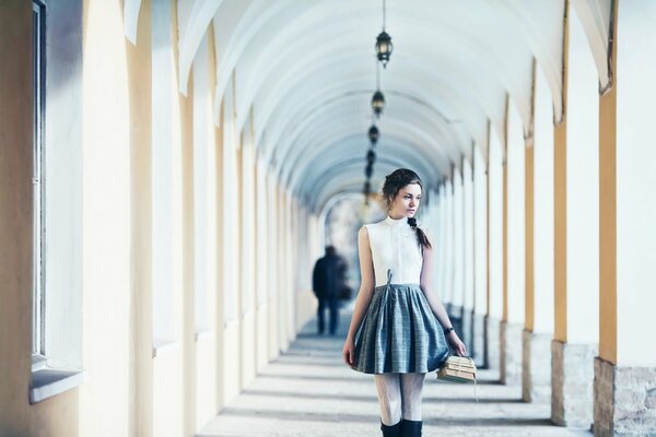 La chica con los libros Mira pensativamente a un lado