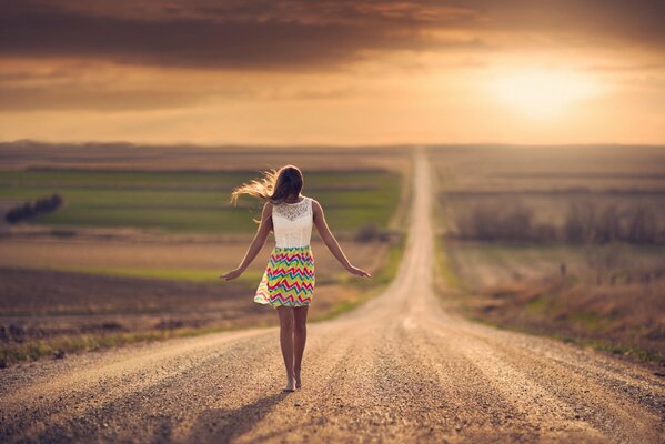 Fille aux pieds nus va sur la route