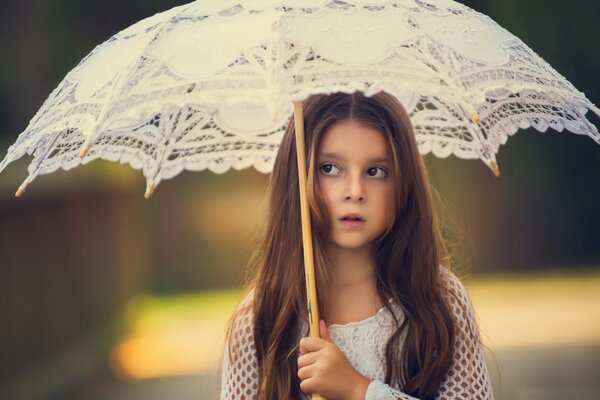 Cute girl under a lace umbrella