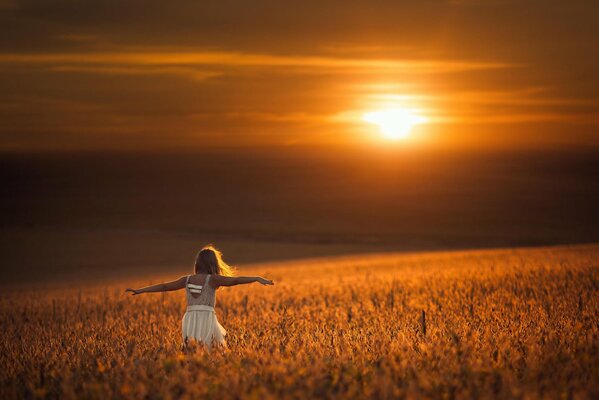 La gamine dans le champ avec le soleil parlé