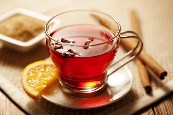 Hot tea with lemon and cinnamon on a full-screen background