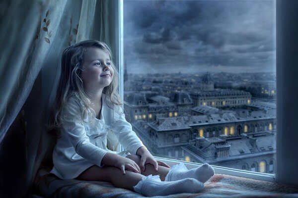 La niña observa la vista desde la ventana y sonríe