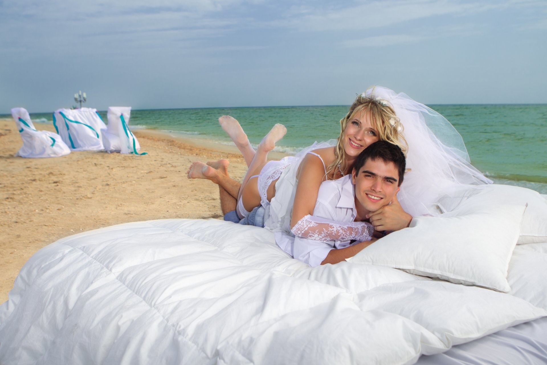 mare spiaggia coppia sposa sposo ragazza bionda fidanzato sorrisi. velo letto cuscino