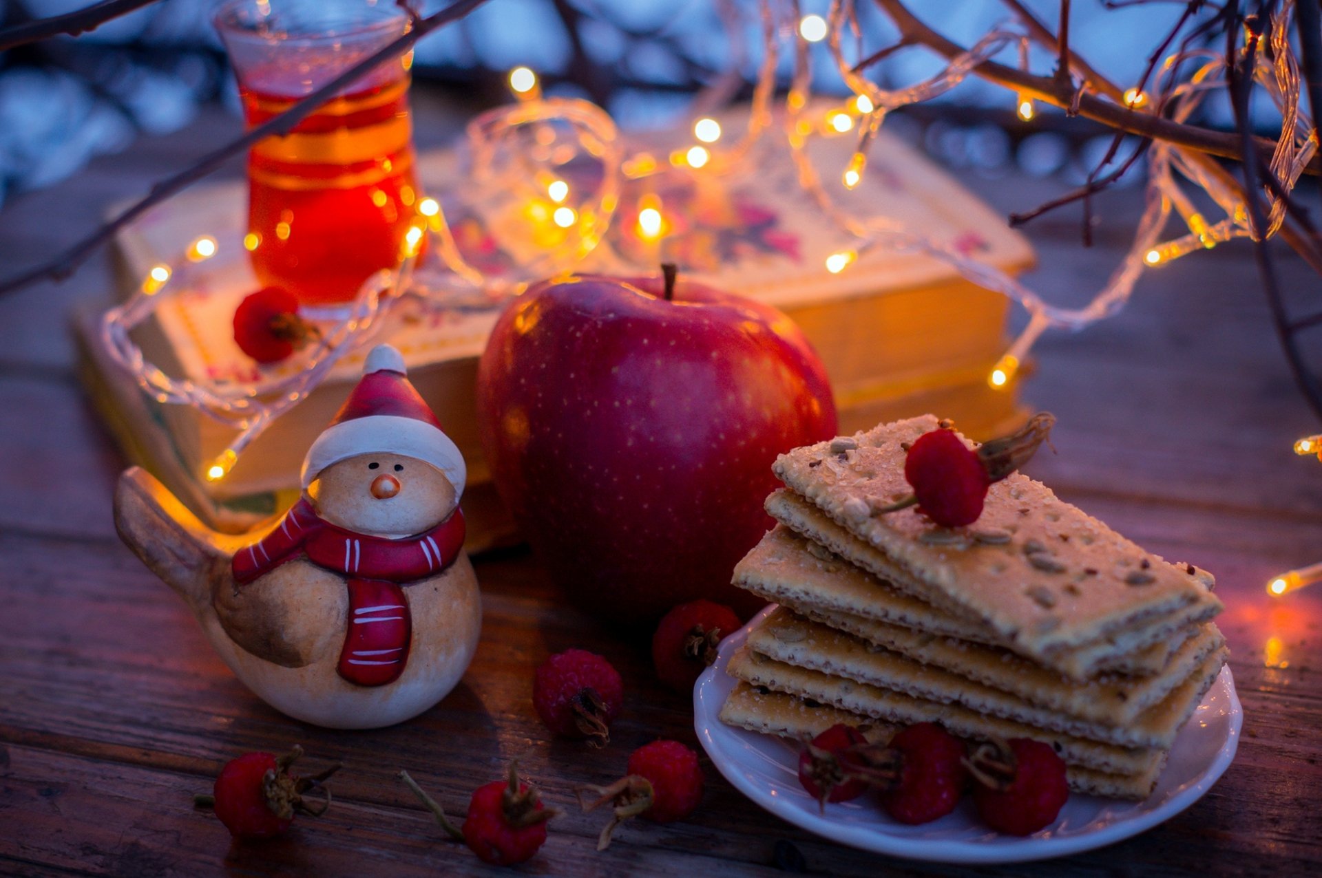 biscotti tè bacche rosso mela libri statuetta ghirlanda luci giallo